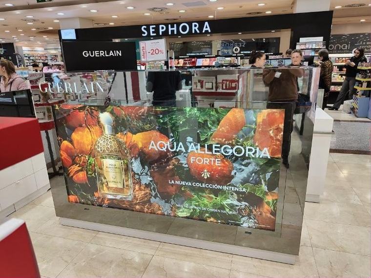 Isla de PLV con gráfica retroiluminada montada en centro comercial